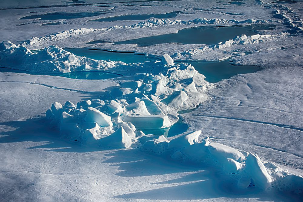 North Pole (88-90 degrees) in 2016. Summer snow morass (melt water pool) and toros (haycock, multi-year ice hummock) on ice of Arctic ocean. Global warming: Ice at North pole will melt in few decades