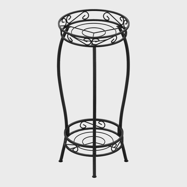 Black metal plant stand features intricate scrollwork, standing upright against a plain gray background.