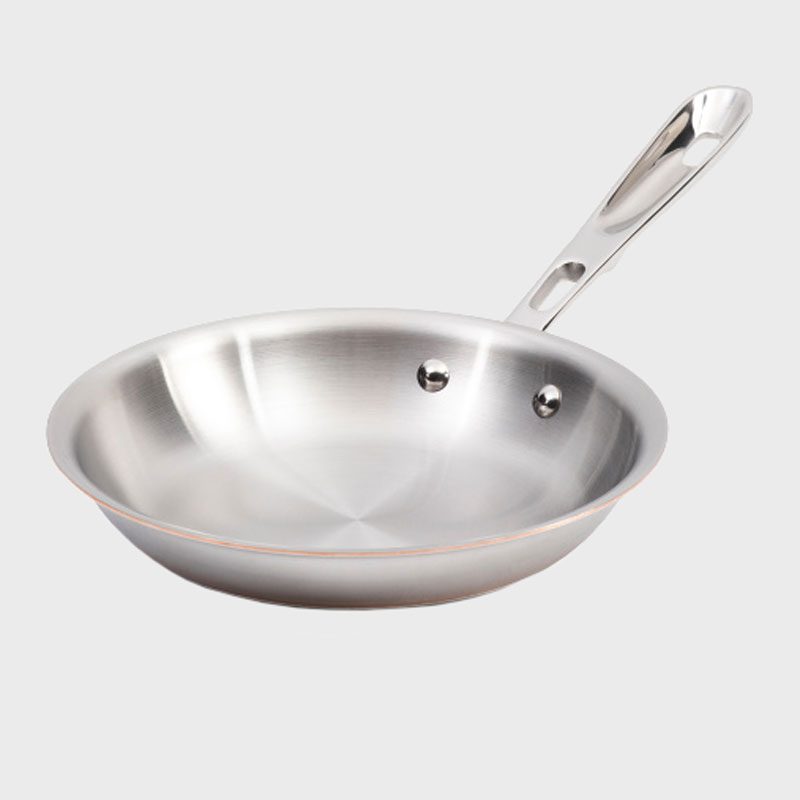 Stainless steel frying pan with a riveted handle, resting on a plain gray background.