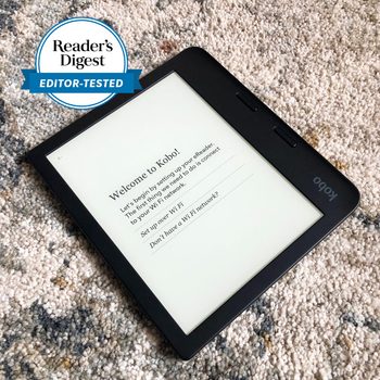 E-reader displays setup instructions on a textured carpet. Circular badge reads, "Reader's Digest Editor-Tested."