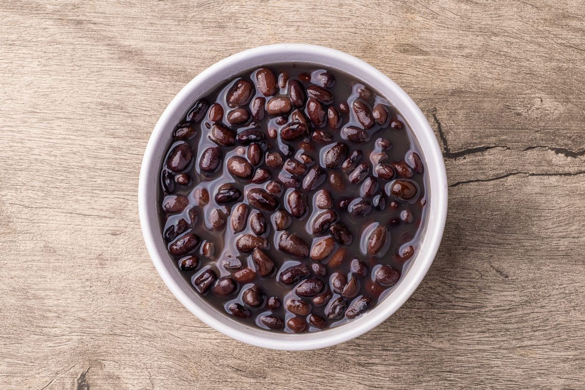 Cooked Black Beans In A Bowl Over Wooden Table