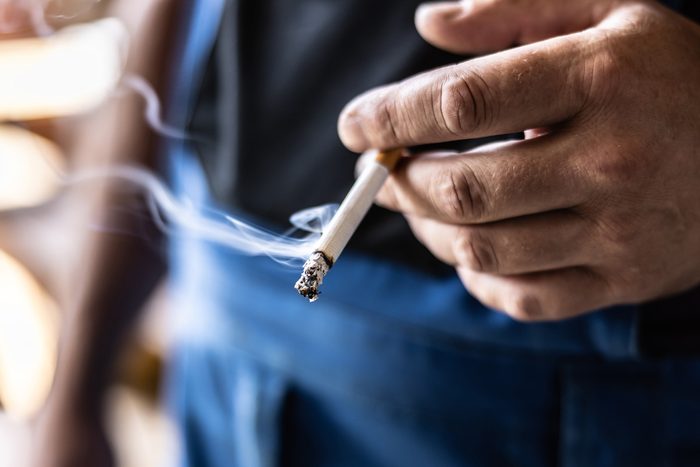 close of hand holding cigarette