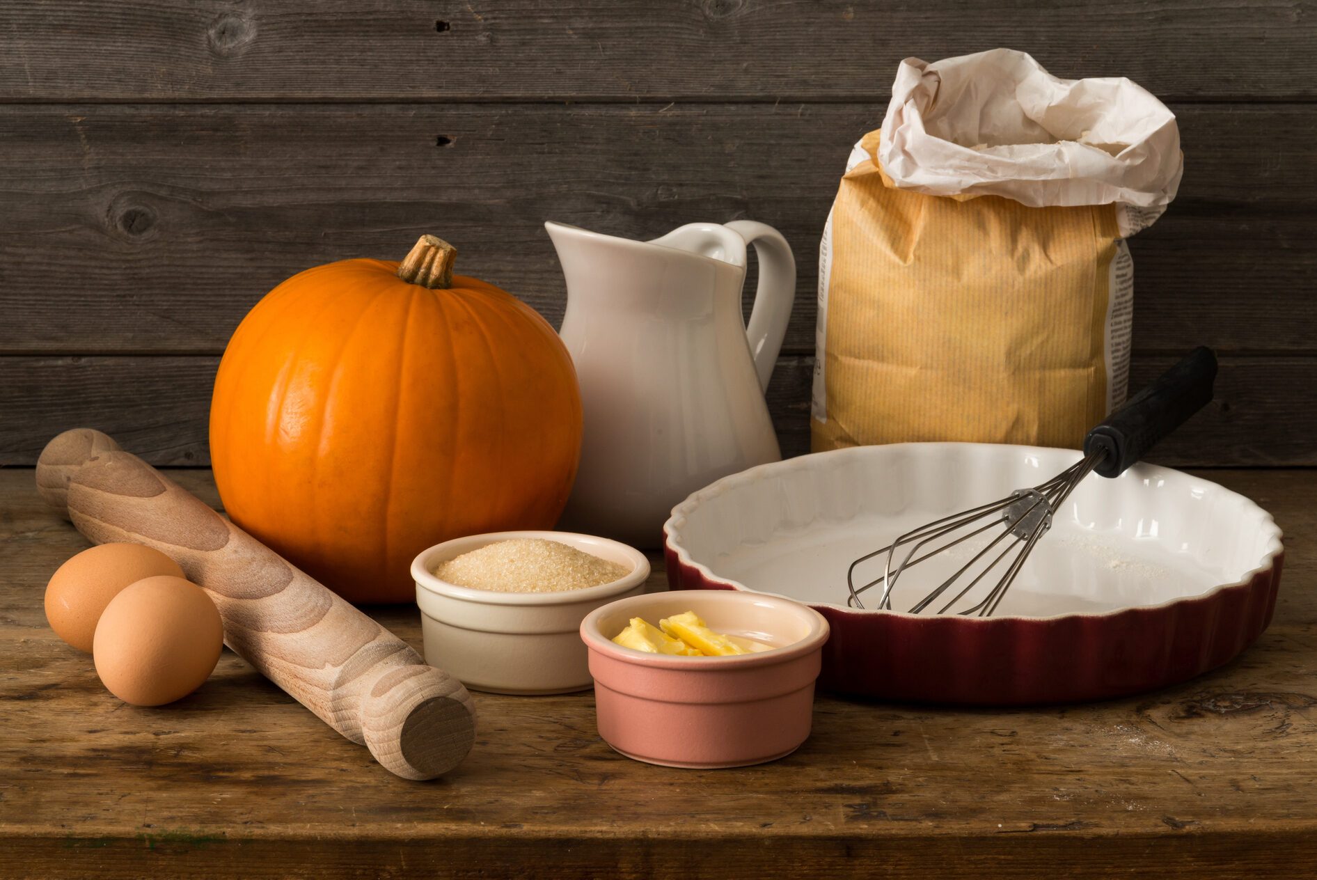 Tools and Ingredients for Pumpkin Pie on Wooden Surface