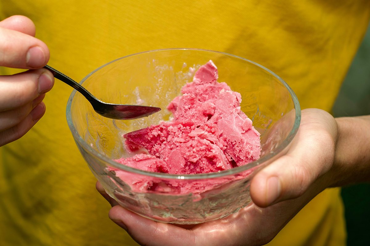 Person eating ice cream with a spoon from a bowl