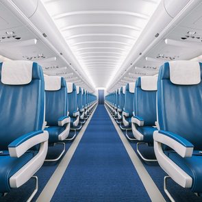 Interior of a commercial airplane cabin with blue leather seats.