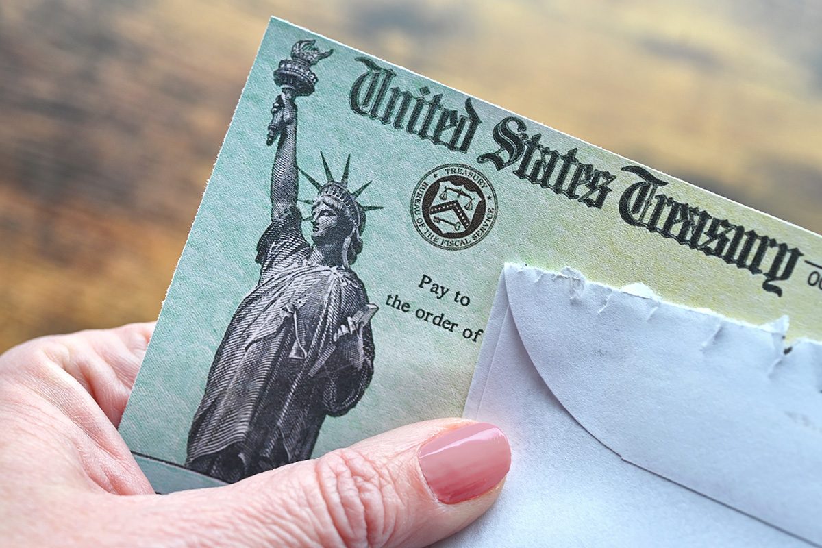 Female holding a check from the United States Treasury